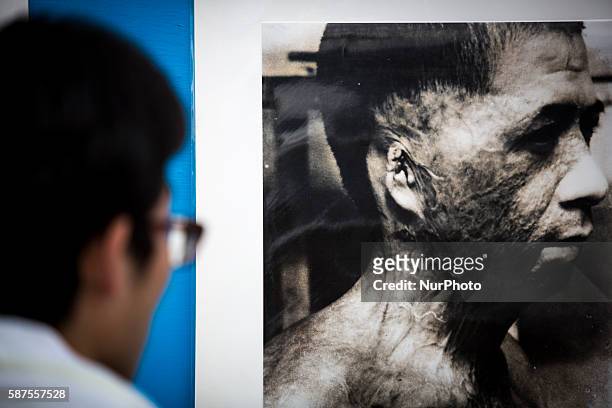 Visitors look at old photos of atomic bomb victims exhibited at Nagasaki Peace Park in Nagasaki during the 71st anniversary of the atomic bombing on...