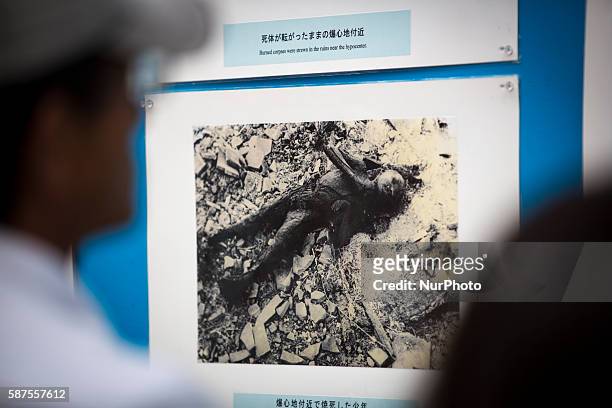 Visitors look at old photos of atomic bomb victims exhibited at Nagasaki Peace Park in Nagasaki during the 71st anniversary of the atomic bombing on...
