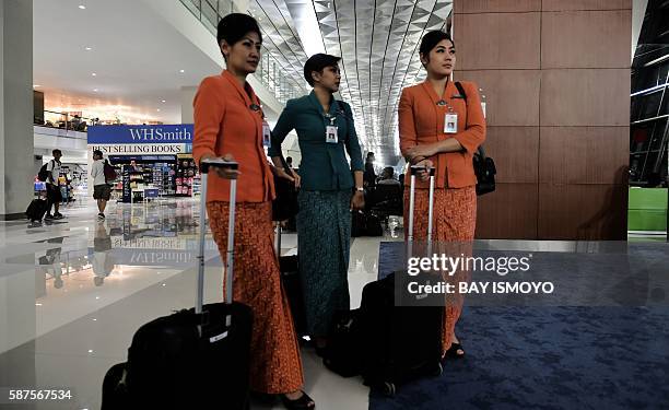 Flight attendants wait to board their flight at the newly opened terminal 3 at Soekarno-Hatta International Airport in Tangerang, on the outskirts of...