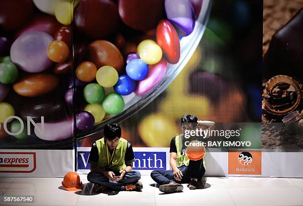 Workers take a rest during the night shift at the newly opened terminal 3 at Soekarno-Hatta International Airport in Tangerang, on the outskirts of...