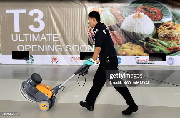 Worker on the night-shift prepares to clean the floor at the newly opened terminal 3 at Soekarno-Hatta International Airport in Tangerang, on the...