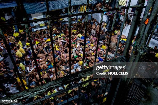 This picture taken on July 21, 2016 shows inmates sleeping at the open basketball court inside the Quezon City jail in Manila. - Philippine officials...