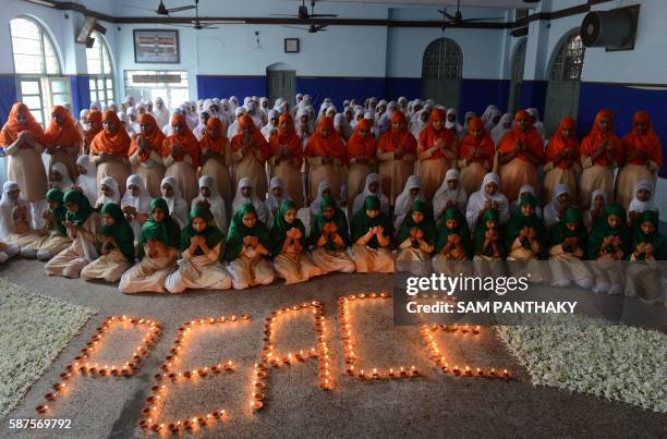 Indian schoolchildren wear the colours of the country's tricolour as they pray for world peace at The Anjuman-E-Islam School in Ahmedabad on August 9...