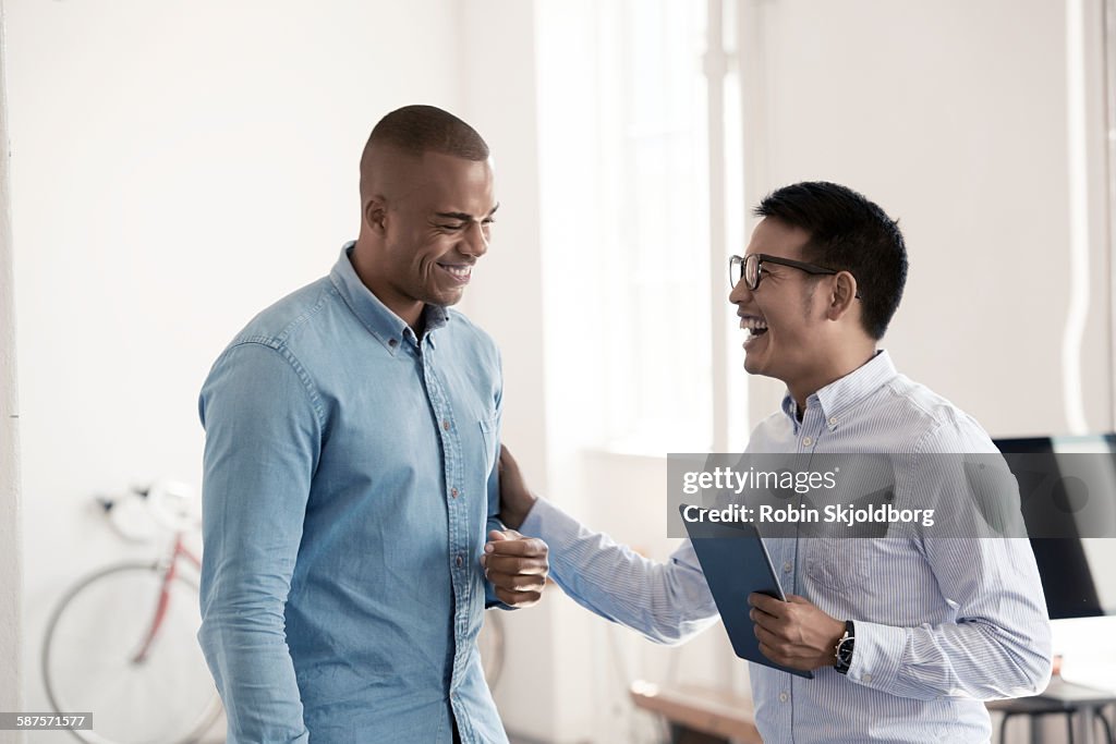 Two Men in creative office laughing
