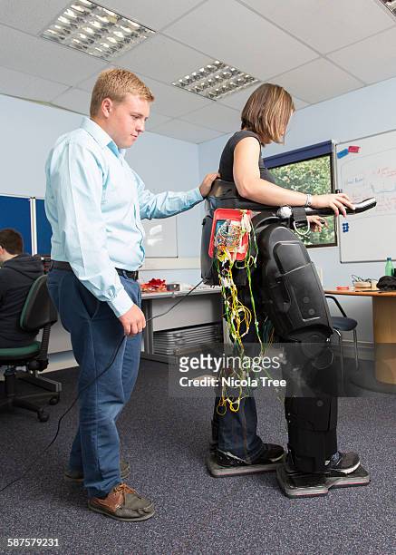 female medical engineer testing a exoskeleton - paralysis stock pictures, royalty-free photos & images