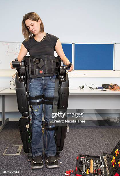 female medical engineer testing an exoskeleton - exosquelette photos et images de collection