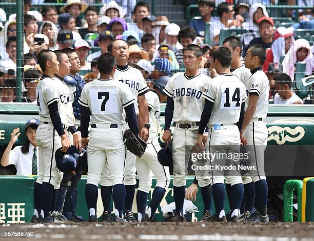 Players of the Nagasaki Commercial High School baseball team observe a moment of silence during its first-round game of the national championship at...