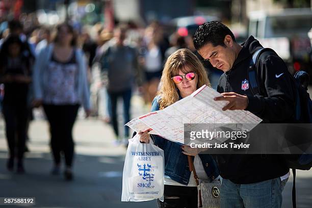 Tourists refer to a map in front of the Houses of Parliament in Westminster on August 9, 2016 in London, England. The UK's tourism industry is set to...