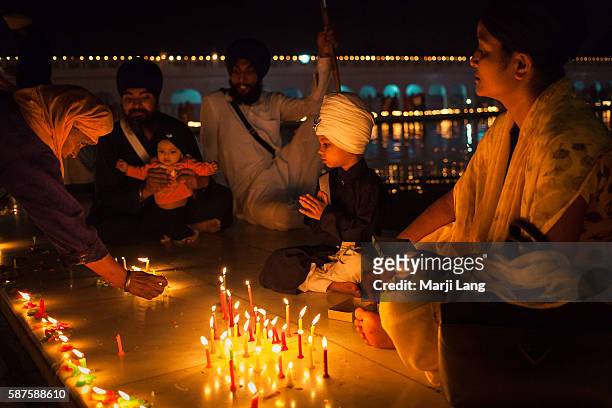 Traditional Sikh family celebrating Diwali festival at night, also called Bandi Chhor Divas celebration for the Sikh religion followers at the...