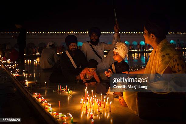 Traditional Sikh family celebrating Diwali festival night, also Bandi Chhor Divas celebration for the Sikh religion followers at the Gurdwara Dukh...