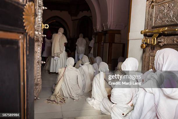 Jain nuns praying inside the Palitana temples complex on Shatrunjaya hill, Gujarat, India.