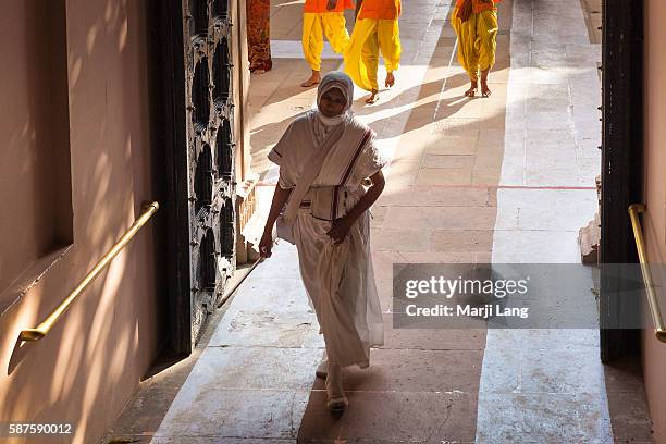 Jain nun walking down the path from Palitana temples on Shatrunjaya hill, Gujarat, India.
