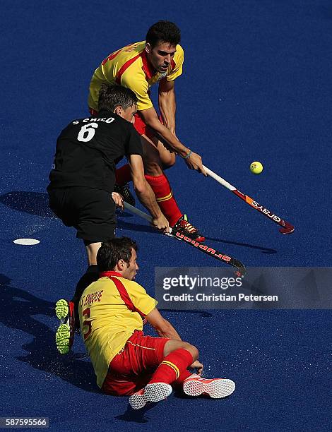 Simon Child of New Zealand shoots to score a goal defended by Andres Mir and Sergi Enrique of Spain during the hockey game on Day 4 of the Rio 2016...