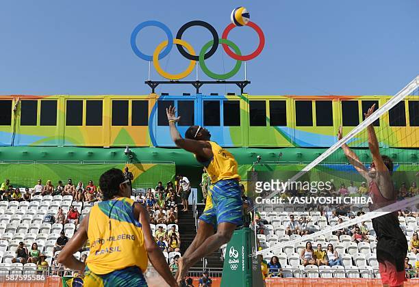 Brazil's Evandro Goncalves Oliveira Junior spikes the ball during the men's beach volleyball qualifying match between Brazil and Canada at the Beach...