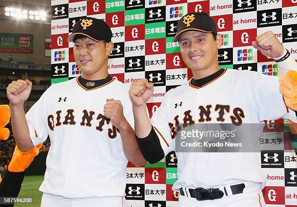 Yomiuri Giants pitcher Tetsuya Utsumi and second baseman Luis Cruz pose for photos after their 5-2 win over the DeNA BayStars at Tokyo Dome on Aug....