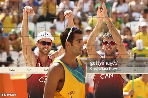 Ben Saxton and Chaim Schalk of Canada celebrate their victory after the Men's Beach Volleyball Preliminary Pool D match against Pedro Solberg and...
