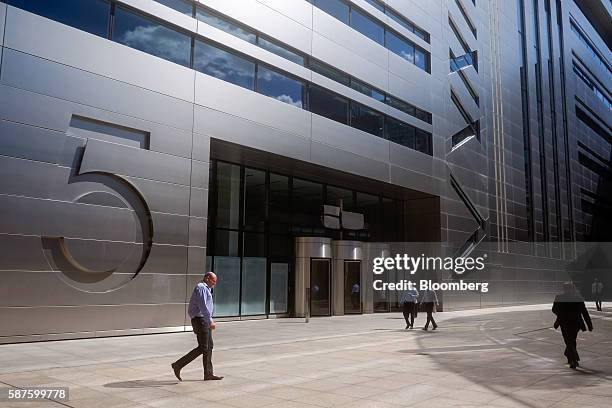 Pedestrians walk past No. 5 Broadgate, an office complex to be occupied by UBS AG, as construction work nears completion in London, U.K., on Tuesday,...