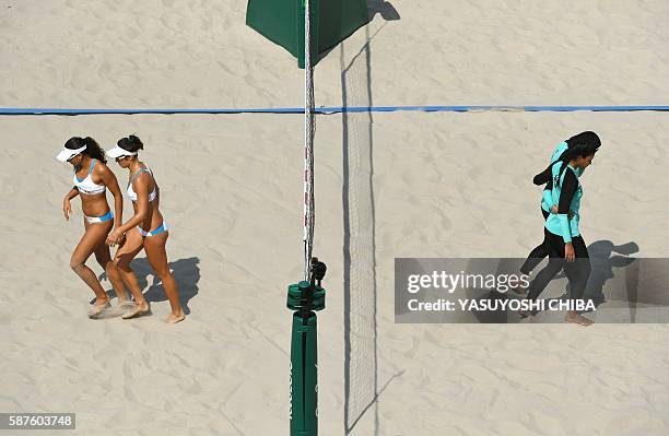 Players prepare to compete in the women's beach volleyball qualifying match between Italy and Egypt at the Beach Volley Arena in Rio de Janeiro on...