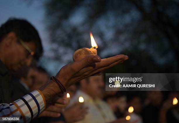 Pakistani journalists hold oil lamps during a vigil to pay tribute to their colleagues and lawyers who were killed a day after a suicide bombing at...