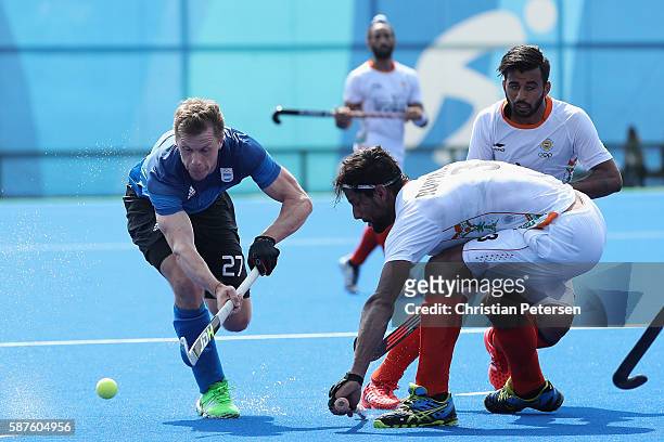 Lucas Rossi of Argentina moves the ball past Rupinder Pal Singh of India during the hockey game on Day 4 of the Rio 2016 Olympic Games at the Olympic...