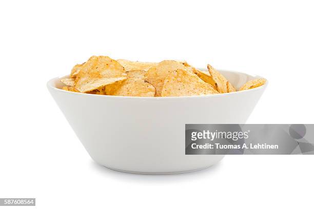 white round bowl full of potato chips viewed from the front, isolated on white background. - schaal stockfoto's en -beelden