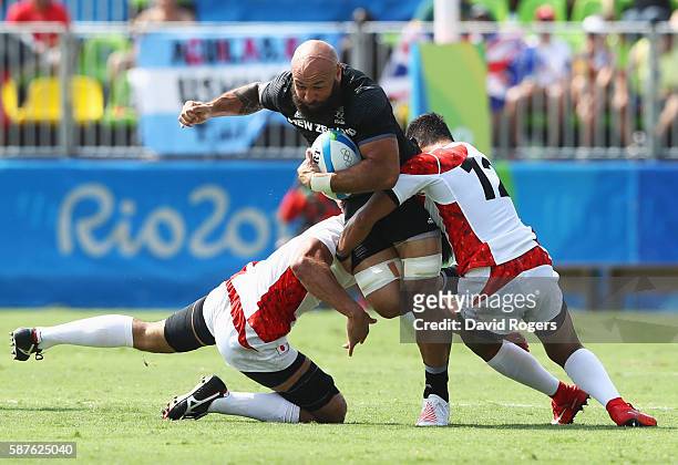 Forbes of New Zealand is tackled by Yusaku Kuwazuru and Kazuhiro Goya of Japan during the Men's Rugby Sevens Pool C match between New Zealand and...