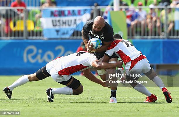 Forbes of New Zealand is tackled by Yusaku Kuwazuru and Kazuhiro Goya of Japan during the Men's Rugby Sevens Pool C match between New Zealand and...