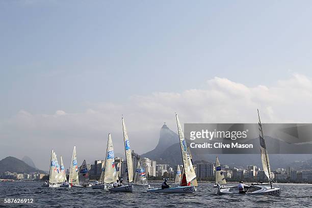 Finn class boats in action with Christ the Redeemer in the background on Day 4 of the Rio 2016 Olympic Games at the Marina da Gloria on August 9,...