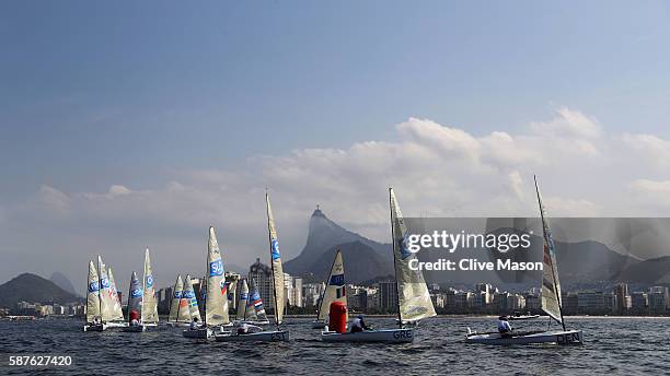 Finn class boats in action with Christ the Redeemer in the background on Day 4 of the Rio 2016 Olympic Games at the Marina da Gloria on August 9,...