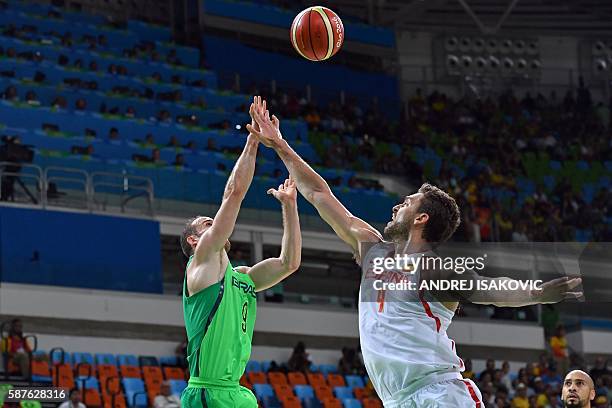 Brazil's point guard Marcelinho Huertas and Spain's centre Pau Gasol go for a rebound during a Men's round Group B basketball match between Spain and...