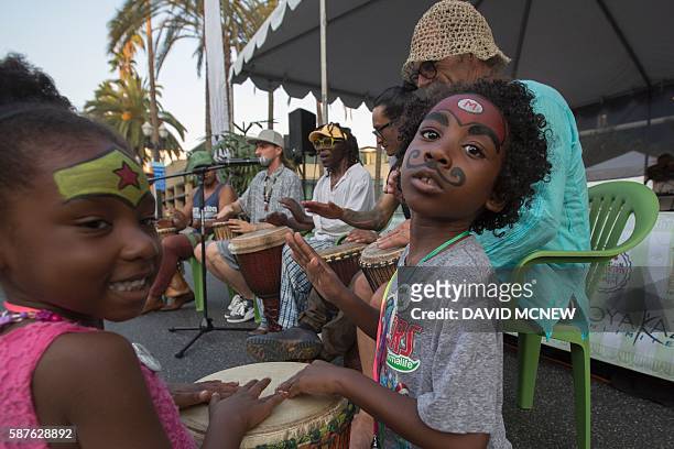 Naila, age four, and Elija Walker ,age six, participate in a drum circle at the 3rd annual Healthy Junk Vegan Faire on July 31, 2016 in Anaheim,...