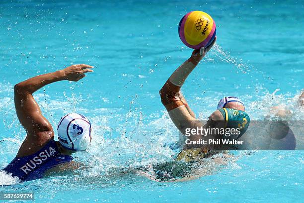Hannah Buckling of Australia passes over Ekaterina Prokofyeva of Russia during the Preliminary Round, Group A Womens Waterpolo match between Russia...