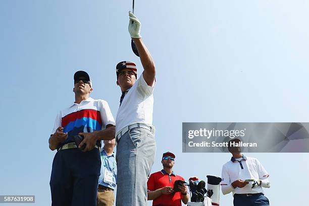 Rickie Fowler of the United States lines up a shot with his caddie Joe Skovron as Matt Kuchar and John Wood look on during a practice round on Day 4...