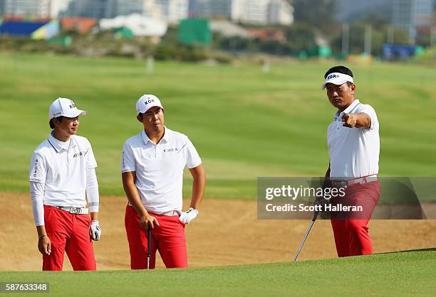 Team leader K.J. Choi work in a bunker with Byeong-Hun An and Jeung-hun Wang of Korea during a practice round on Day 4 of the Rio 2016 Olympic Games...