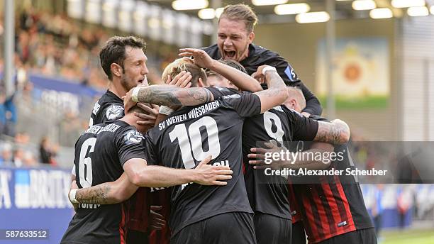 Robert Andrich of Wiesbaden celebrates the third goal for his team with Kevin Pezzoni of Wiesbaden and Manuel Schaeffler of Wiesbaden during the...