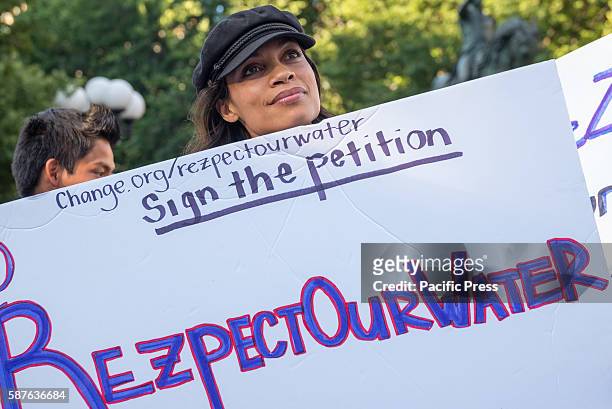 Rosario Dawson holds a sign while listenening as one of the rally speakers speaks. Following the recent approval by the U.S. Army Corps of Engineers...