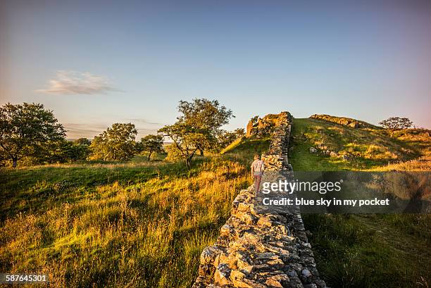 walking hadrians wall at sunset - northumberland stock-fotos und bilder