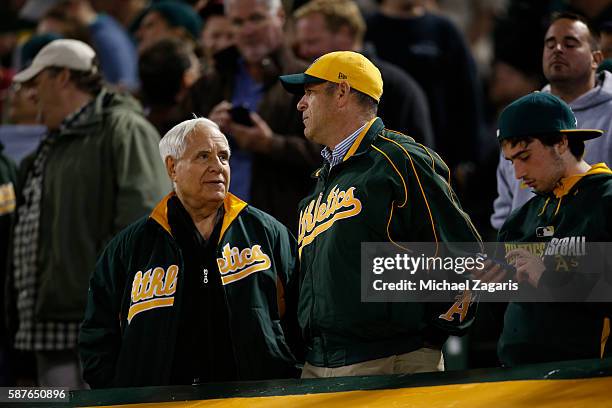Owner Lew Wolff and Owner John Fisher of the Oakland Athletics talk in the stands during the game against the Houston Astros at the Oakland Coliseum...