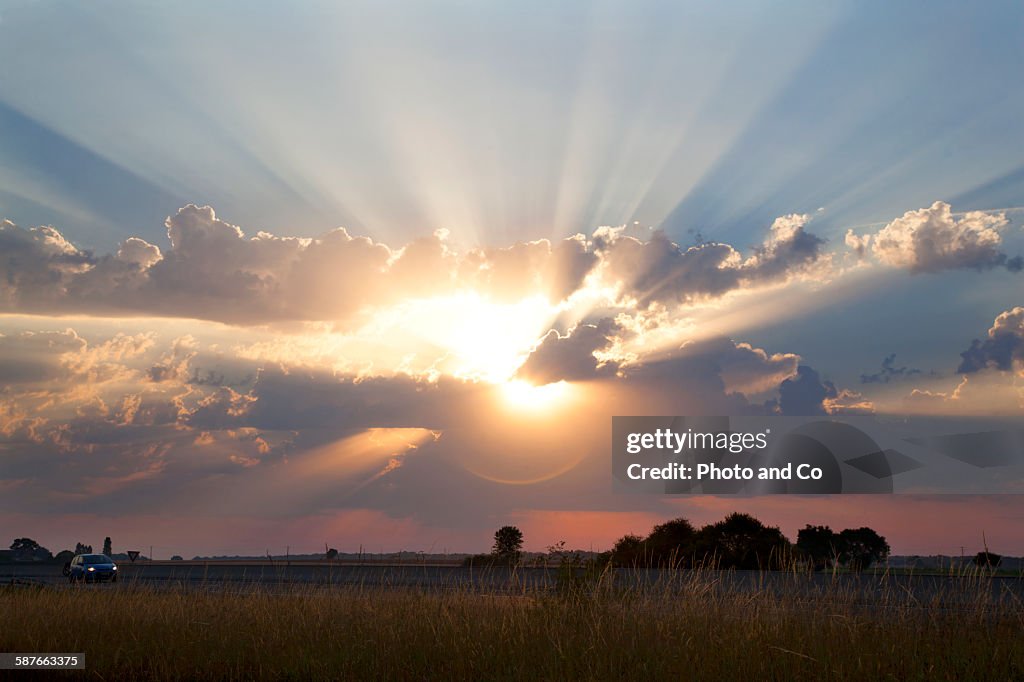 Sun shining through cumulus clouds