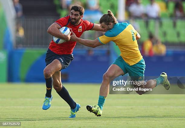 Javier Carrion of Spain holds off Lewis Holland of Australia during the Men's Rugby Sevens Pool B match between Australia and Spain on Day 4 of the...