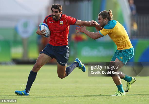 Javier Carrion of Spain holds off Lewis Holland of Australia during the Men's Rugby Sevens Pool B match between Australia and Spain on Day 4 of the...