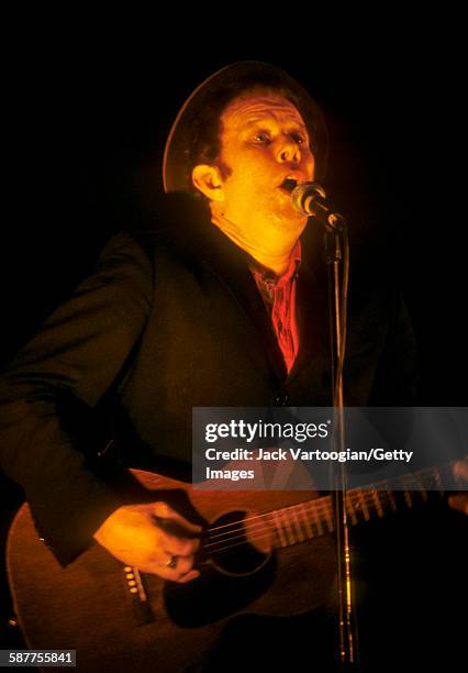 American musician Tom Waits plays guitar as he performs at the Beacon Theater, New York, New York, September 23, 1999.