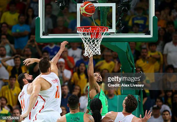 Marcus Vinicius Marquinhos of Brazil scores the winning basket against Victor Claver and Nikola Mirotic of Spain to win 66-65 during a preliminary...