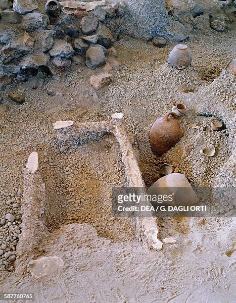Outline of a bed frame and terracotta vases, archaeological site of Akrotiri, Santorini island, Greece. Greek civilisation, 20th-17th century BC.