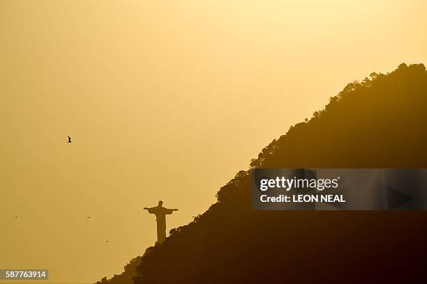 Picture taken from the Beach Volley Arena in Rio de Janeiro shows the Christ the Redeemer statue, located at the peak of the 700 metre Corcovado...