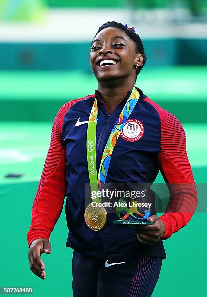 Simone Biles of the United States simles with her gold medal after the medal ceremony for the Artistic Gymnastics Women's Team on Day 4 of the Rio...