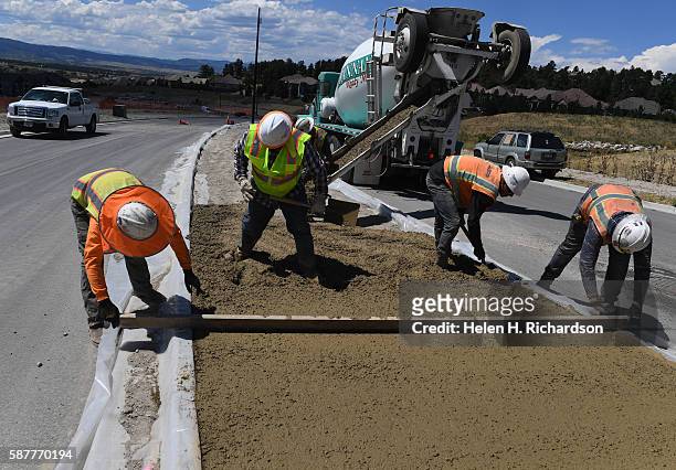 Crews work on putting concrete in the new median on Castle Rock Parkway west of the I-25 interchange on August 9, 2016 in Castle Rock, Colorado. This...