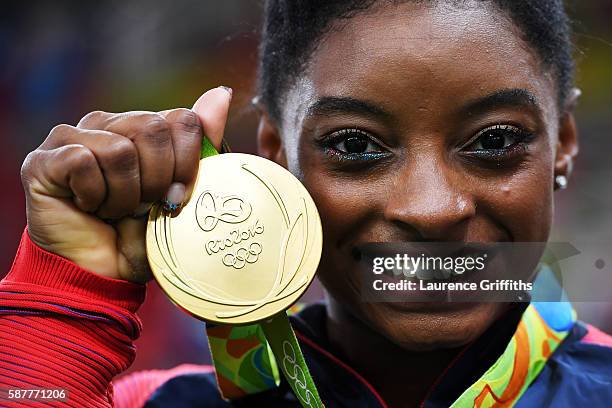 Simone Biles of the United States poses for photographs with her gold medal after the medal ceremony for the Artistic Gymnastics Women's Team on Day...