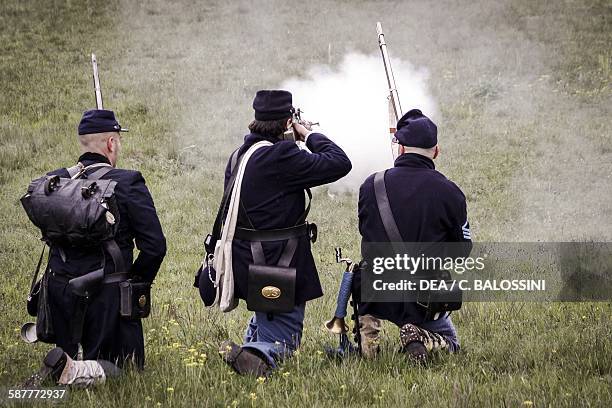 Volunteer soldiers of the Union army firing their muzzle-loading percussion rifles. American Civil War, 19th century. Historical reenactment.