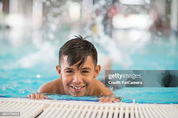 kicking at the edge if the pool - boy swimming stock pictures, royalty-free photos & images